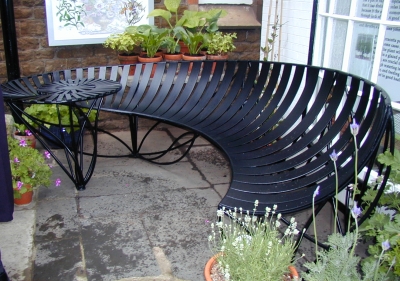 Ammonite inspired ironwork bench, designed by Adrian Moakes, for North Lincs Museum, Scunthorpe.  Fabricated and installed by Luke Lister Blacksmiths, 2002