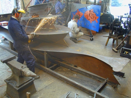 Martin in Luke Lister workshop grinding rough edges of large amphora section